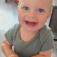 Noah is registered to the contest to win money with this photo: child, toddler, smiling, happy, indoor, toy, play, person, face, cute, clothing, short_sleeves, blond_hair, hands, floor, furniture, background, expression, teeth, eyes