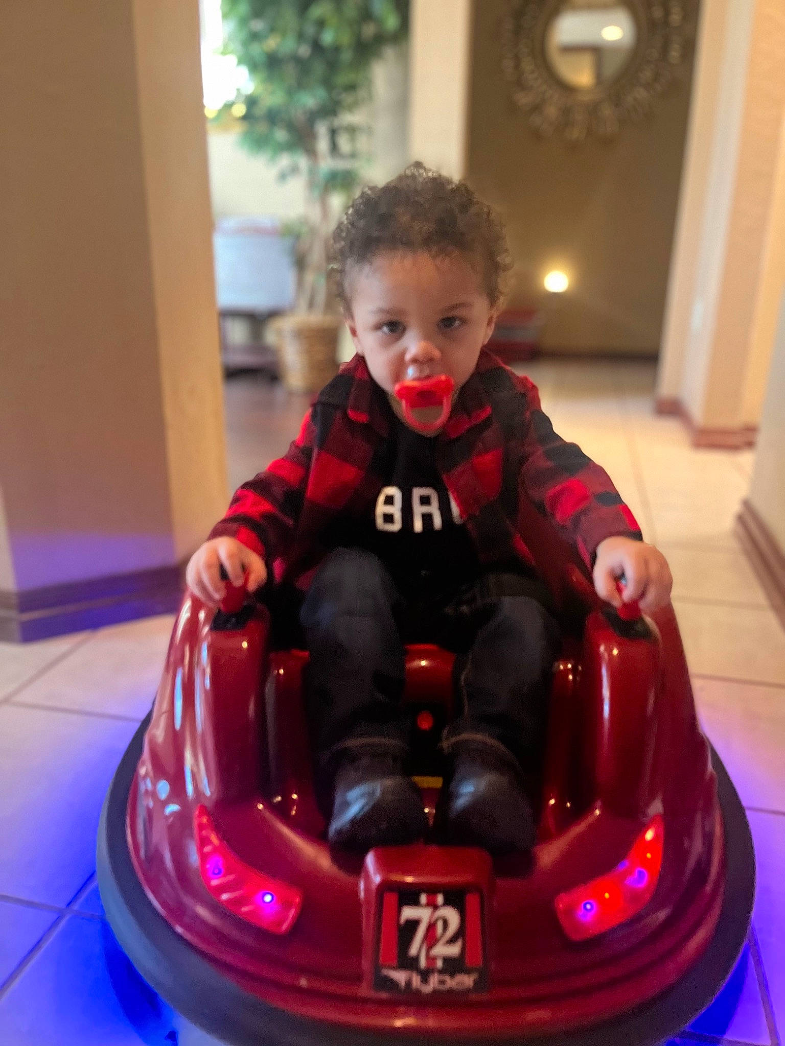 Zaiden is registered to the contest to win money with this photo: automotive_design, automotive_exterior, automotive_lighting, baby, bumper, car, child, flooring, fun, happy, hood, motor_vehicle, person, recreation, riding_toy, sitting, smile, toddler, toy, toy_vehicle