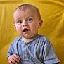 Daors is registered to the contest to win money with this photo: baby, child, infant, smiling, blue_shirt, wooden_buttons, pin, yellow_background, portrait, cute, happy, sitting, face, eyes, mouth_open, short_hair, skin, indoors, soft_light, closeup