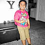 child, boy, headphones, backpack, super_mario, tshirt, shorts, sneakers, indoor, carpet, furniture, blurred_background, smiling, standing, person, casual_clothing, young, playful, portrait, colorful