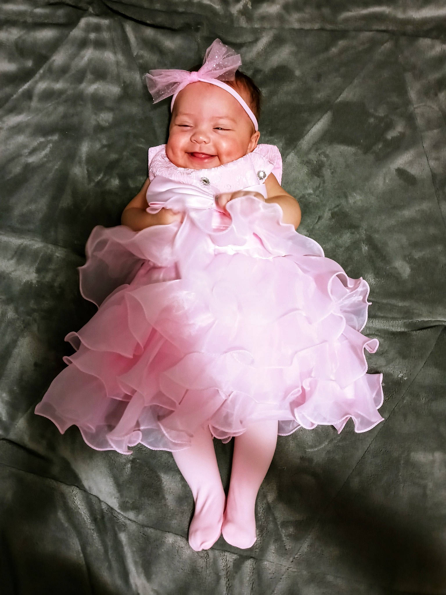 Jaycee is registered to the contest to win money with this photo: baby, baby_toddler_clothing, bonnet, child, child_model, clothing, costume, costume_accessory, day_dress, dress, embellishment, facial_expression, hair_accessory, headgear, headwear, joy, magenta, one_piece_garment, person, pink