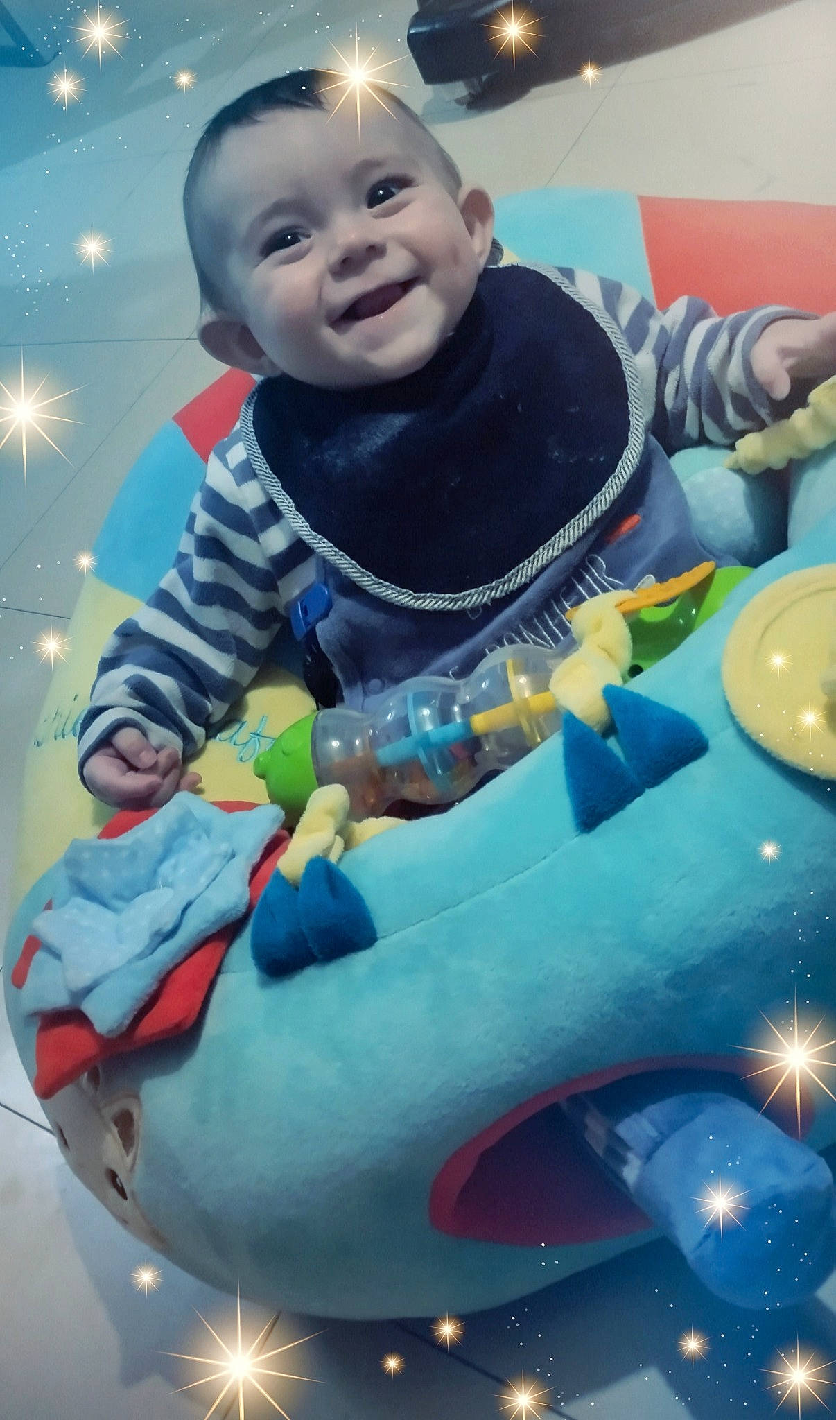 Hugo a rejoint le concours — aidez-le/la à gagner de superbes lots ! baby, baby_products, baby_toddler_clothing, baby_toys, child, electric_blue, fictional_character, fun, happy, joy, leisure, party_supply, person, photograph, play, recreation, sitting, smile, snapshot, t_shirt