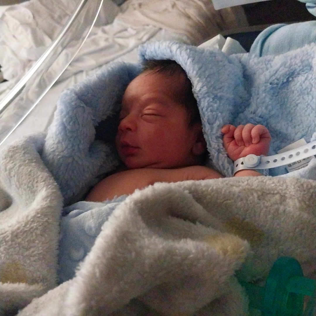 Michael is registered to the contest to win money with this photo: architecture, baby, bed, bedroom, blanket, building, clothing, face, furniture, glove, head, hospital, indoors, newborn, person, photography, portrait, quilt, room, sleeping