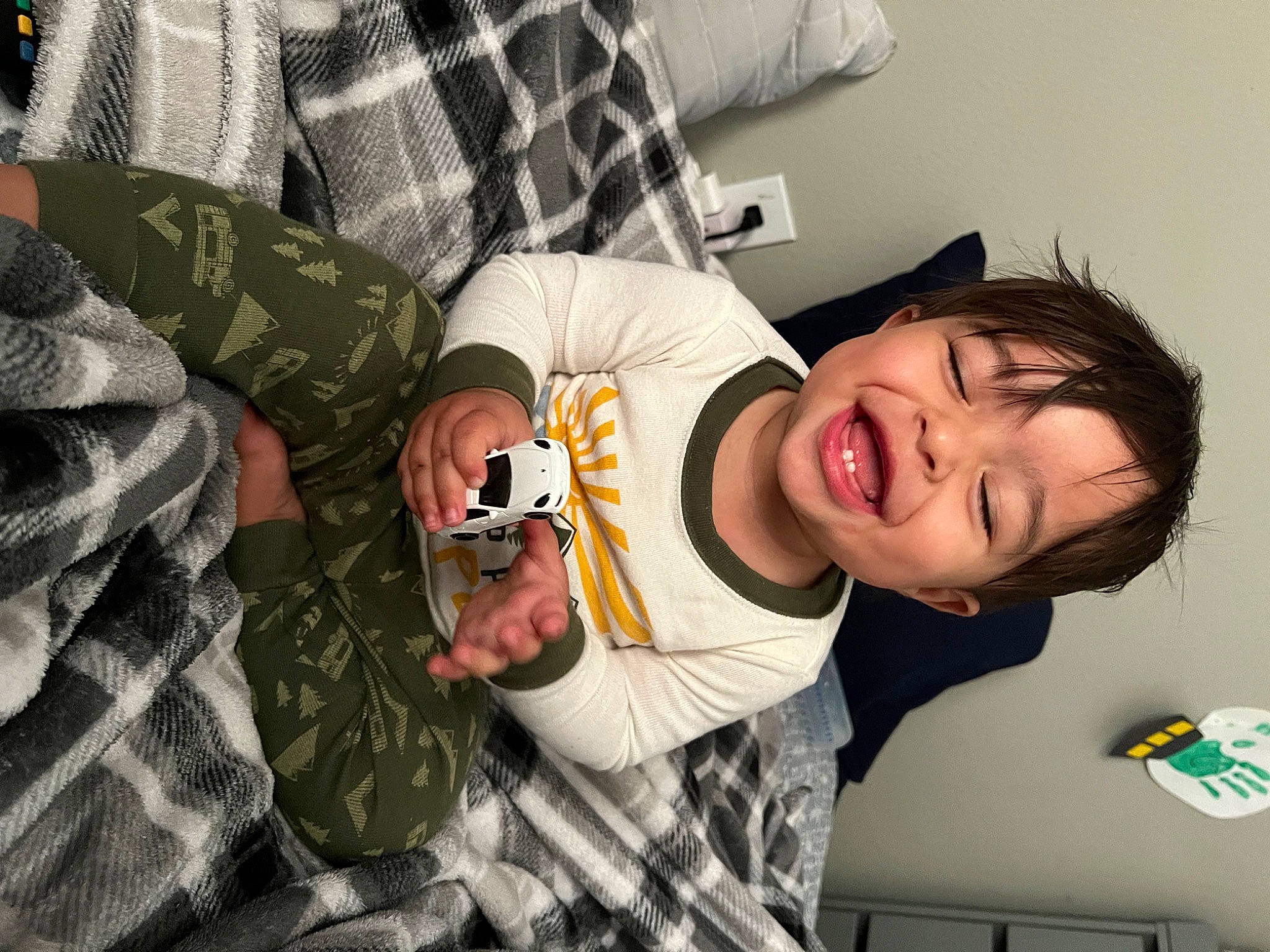 Kailo is registered to the contest to win money with this photo: arm, child, comfort, cool, elbow, eyewear, finger, fun, gesture, happy, military_camouflage, mouth, pattern, person, plaid, sitting, sleeve, smile, t_shirt, tartan