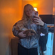 Max joined the competition — help win amazing prizes! black_pants, casual, cat, clothing, glasses, hand, hoodie, indoor, lamp, long_hair, mirror, orange_tabby, person, phone, reflection, relaxed_cat, room, selfie, smile, warm_lighting