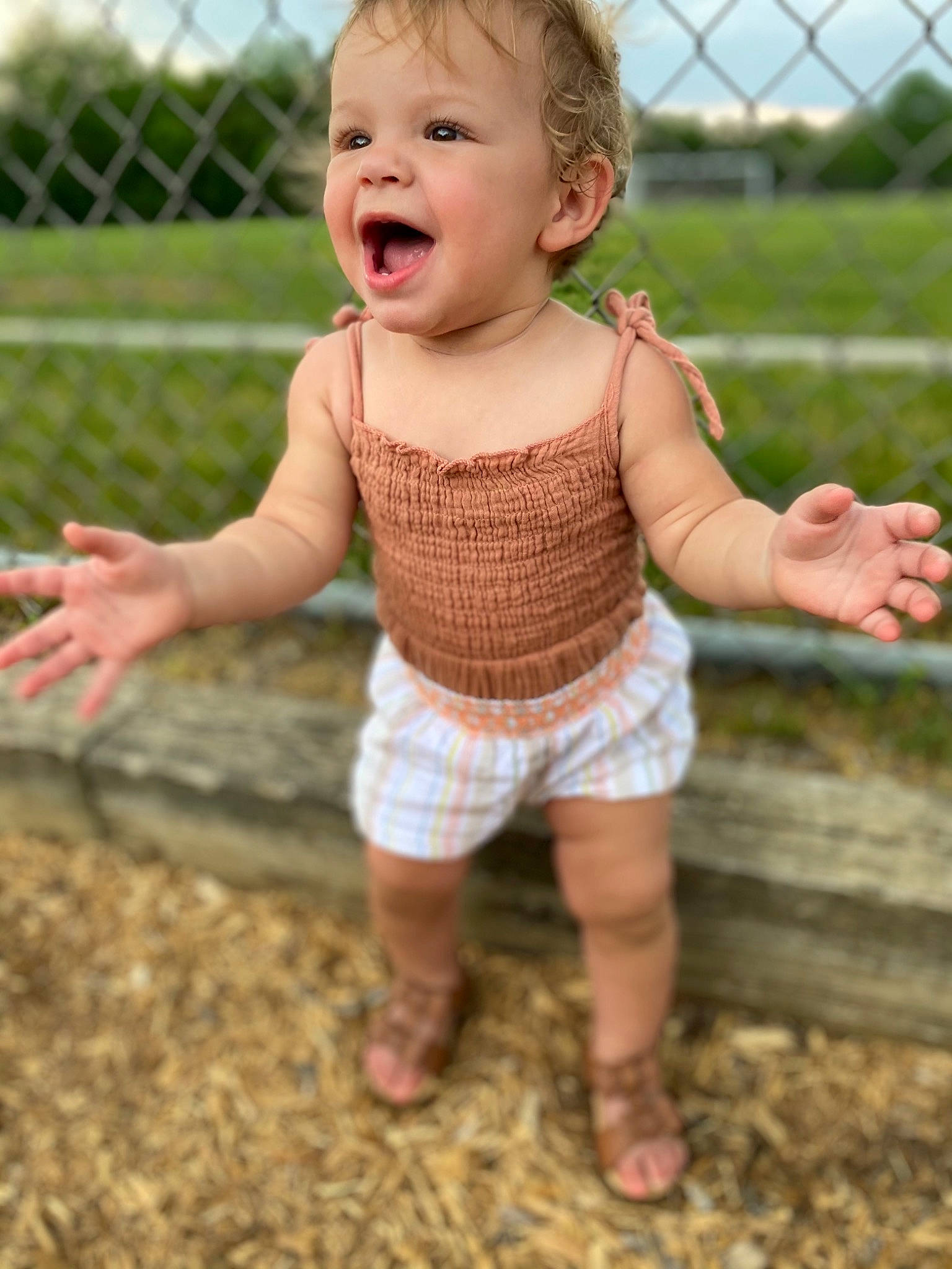Naiomi joined the competition — help win amazing prizes! baby, baby_toddler_clothing, barefoot, child, face, finger, fun, grass, hairstyle, happy, human_body, human_leg, leg, people_in_nature, person, sitting, skin, sleeve, smile, thumb