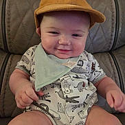 Blake joined the competition — help win amazing prizes! baby, child, smiling, hat, cap, bandana, bib, onesie, animal_print, patterned_clothing, leather_chair, seat, portrait, indoors, cute, chubby_cheeks, hands, legs, relaxed, dapper