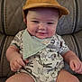 baby, child, smiling, hat, cap, bandana, bib, onesie, animal_print, patterned_clothing, leather_chair, seat, portrait, indoors, cute, chubby_cheeks, hands, legs, relaxed, dapper