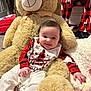 baby, teddy_bear, pajamas, red, white, smiling, indoor, blanket, plush, child, holiday, christmas, cute, cozy, soft, person, floor, furniture, decor, toy