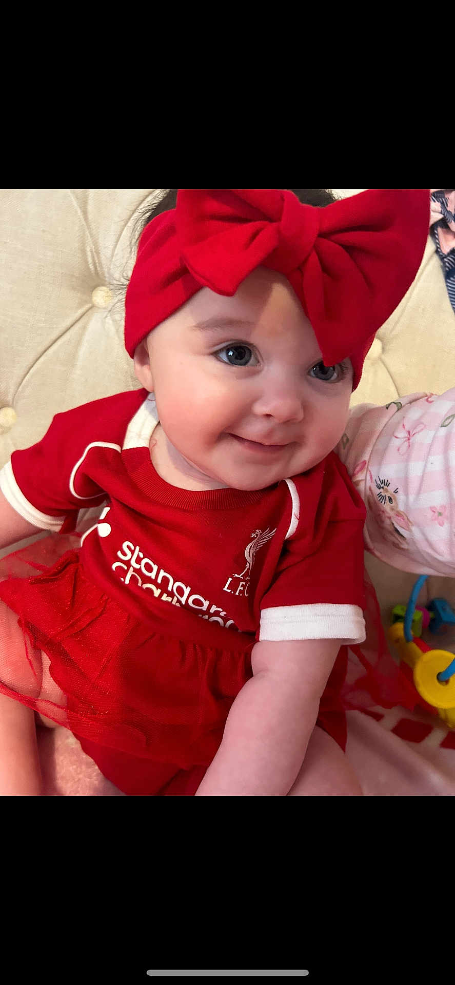 Ivy-Rae joined the competition — help win amazing prizes! baby, child, red_clothing, headband, bow, smile, face, sitting, cushion, toy, indoors, cute, portrait, happy, person, toddler, infant, clothing, fabric, closeup