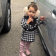 Naissa a rejoint le concours — aidez-le/la à gagner de superbes lots ! child, earmuffs, coat, pink_boots, pants, standing, car, reflection, sidewalk, outdoor, curious, finger_on_lip, fashion, winter, young, person, casual, cute, vehicle, pavement