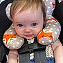 baby, child, car_seat, neck_pillow, fox_pattern, smile, blue_eyes, infant, seatbelt, clothing, cute, portrait, indoor, head_support, baby_toy, young_child, polka_dots, soft_toys, happy, closeup