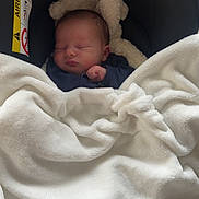 Islem participe au concours pour gagner de l'argent avec cette photo : baby, blanket, car_seat, child, cozy, comfort, cute, face, headrest, infant, newborn, peaceful, resting, sleeping, soft, toddler, transport, warning_label, white_blanket, yellow_label