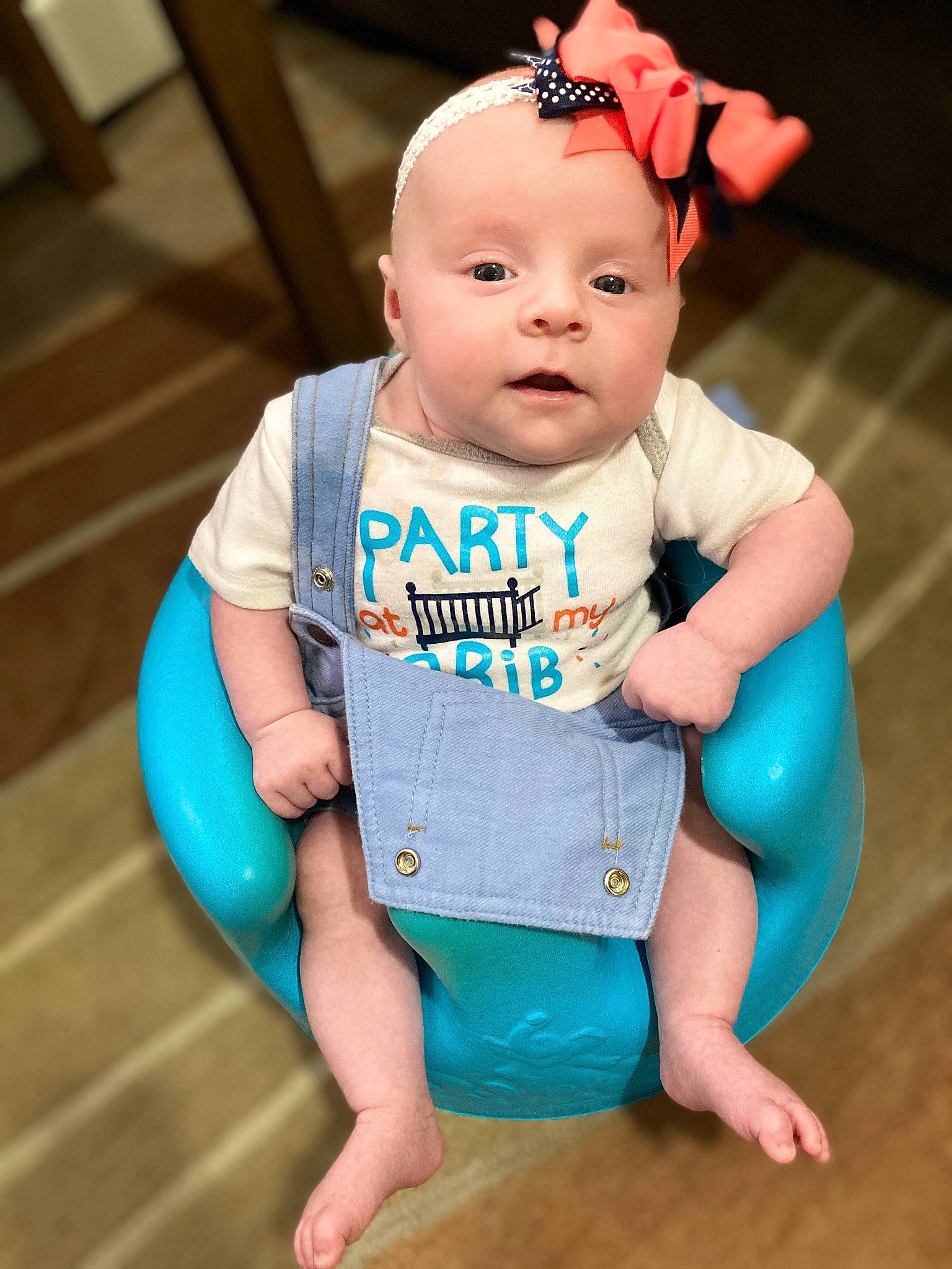 Gracelynn is registered to the contest to win money with this photo: arm, baby, baby_toddler_clothing, cheek, child, electric_blue, finger, flooring, foot, fun, happy, human_body, human_leg, person, pink, sitting, skin, sleeve, t_shirt, thigh