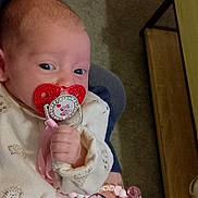 Néllya a rejoint le concours — aidez-le/la à gagner de superbes lots ! animal_print, baby, carpet, child, clothing, cozy, cute, furniture, hand, holding, home, indoor, infant, newborn, pacifier, person, pink_accessory, portrait, small_hand, white_outfit