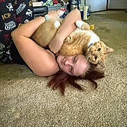 Kitty joined the competition — help win amazing prizes! person, cat, cats, orange_cat, pet, cuddling, lying_down, upside_down, carpet, indoor, home, living_room, human_face, smiling, red_hair, animal_companion, playful, funny, furniture, flowers