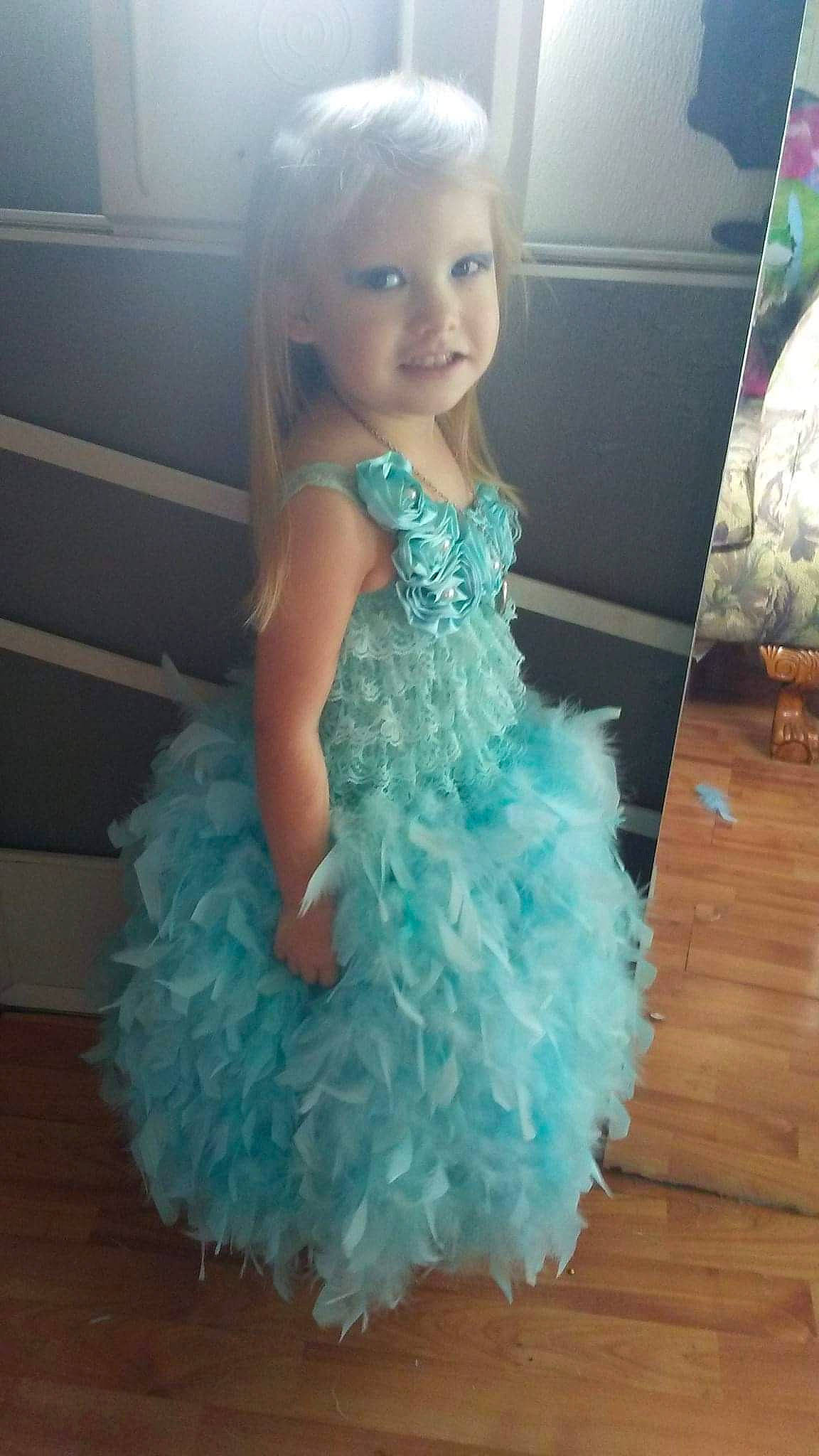 Carolyn is registered to the contest to win money with this photo: aqua, blue, bridal_party_dress, child, clothing, cocktail_dress, costume, dress, formal_wear, gown, person, ruffle, shoulder, toddler, turquoise