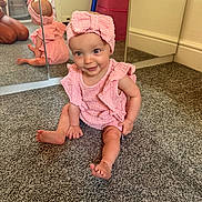 Arabella joined the competition — help win amazing prizes! baby, pink_outfit, headband, bow, carpet, mirror, reflection, smiling, indoor, child, cute, sitting, floor, person, infant, happy, playful, home, portrait, young_child