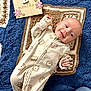 Monroe joined the competition — help win amazing prizes! baby, infant, two_months, onesie, lion_print, crocheted_blanket, blue_blanket, brown_blanket, white_blanket, wooden_sign, flowers, smiling, lying_down, cute, milestone_sign, cozy, child, portrait, indoor, soft_lighting