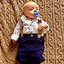 baby, infant, pacifier, clothing, suspenders, white_shirt, navy_pants, blanket, texture, lying_down, hand, foot, face, head, expression, indoors, cute, child, young, portrait