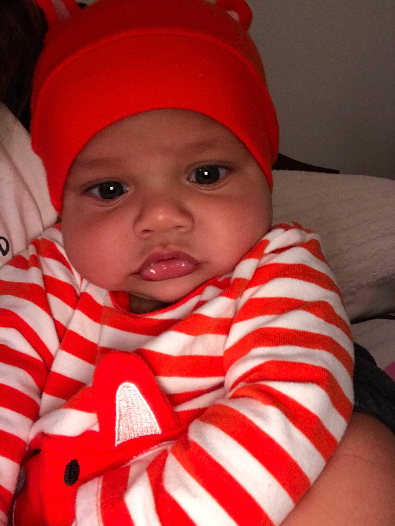 Abram is registered to the contest to win money with this photo: baby, bonnet, cheek, child, face, head, headgear, knit_cap, lip, mouth, person, red, skin, smile, toddler