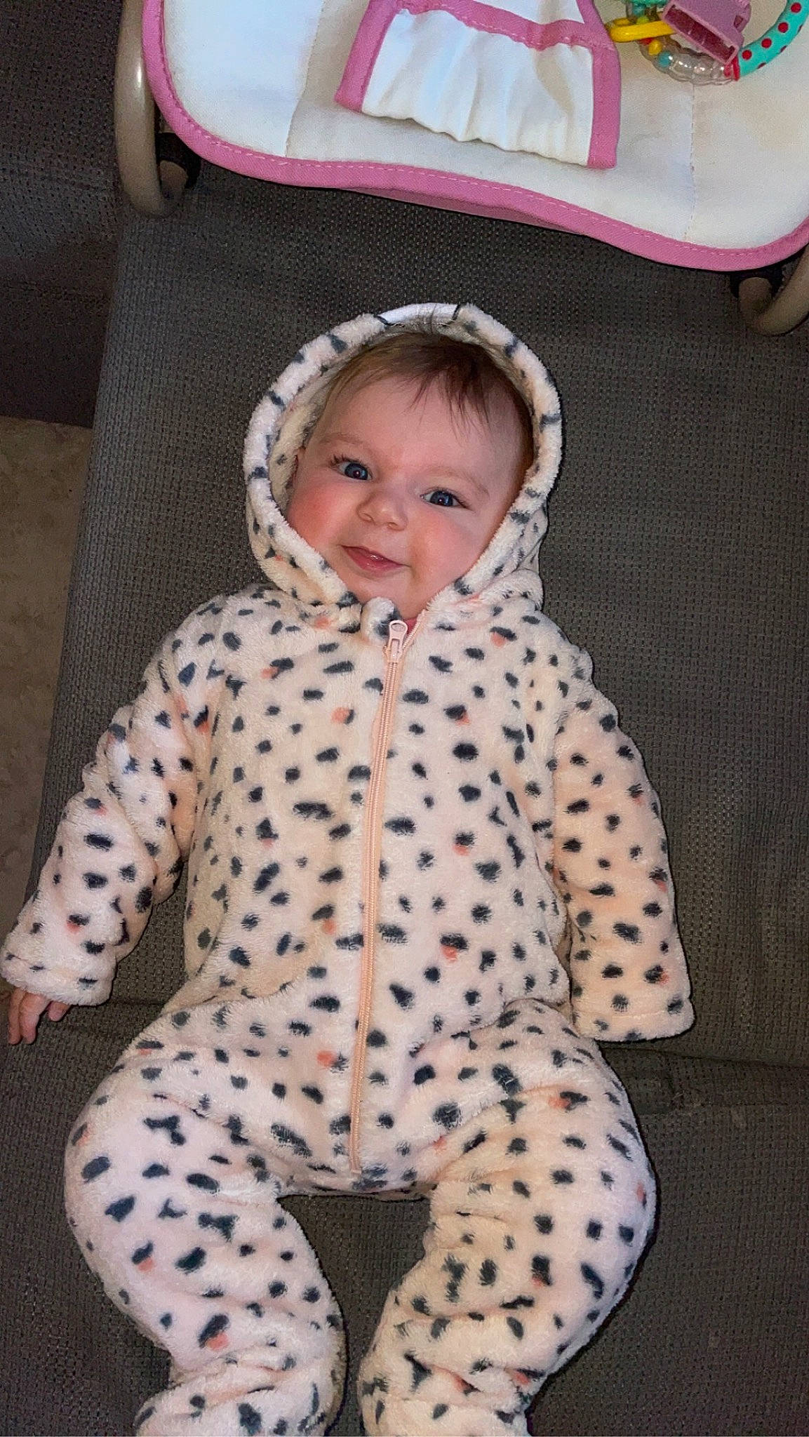 Mya participe au concours pour gagner de l'argent avec cette photo : baby, baby_toddler_clothing, comfort, eye, face, facial_expression, happy, head, headgear, jacket, linens, outerwear, pattern, person, pink, skin, sleeve, smile, textile, toddler