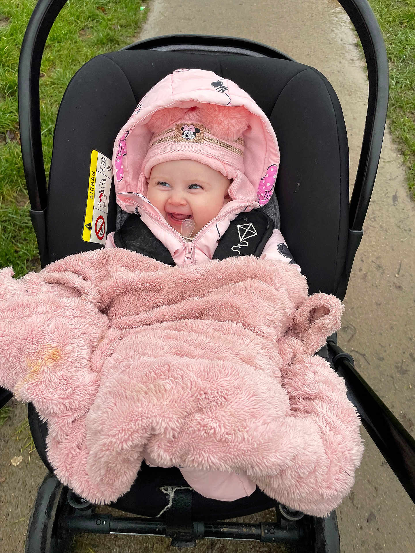 Rosalie-Marie is registered to the contest to win money with this photo: baby, blanket, bundle, child, cute, face, grass, happy, hat, hood, infant, jacket, outdoor, person, pink, seat, sidewalk, smile, stroller, winter_clothing