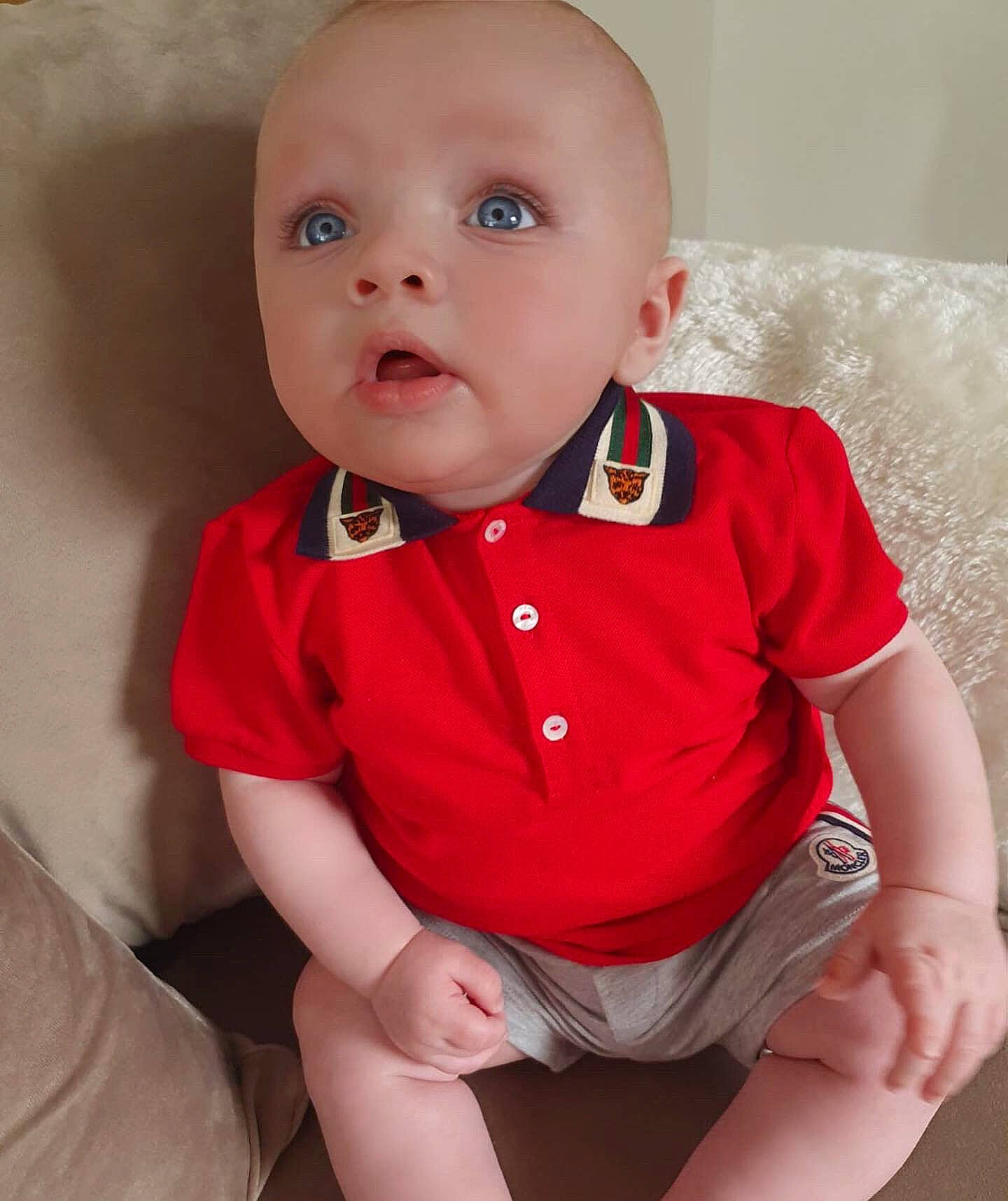 Carlo is registered to the contest to win money with this photo: baby, baby_toddler_clothing, cheek, child, child_model, chin, eye, face, head, leg, lip, mouth, neck, nose, person, pink, red, sitting, skin, standing