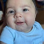 baby, child, face, smile, blue_shirt, chubby_cheeks, portrait, cute, infant, indoors, person, happy, young_child, apparel, sitting, skin, eyes, head, nose, mouth