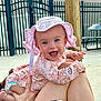 baby, child, smiling, hat, pink, floral, outdoor, fence, person, legs, diaper, happy, cute, blue_eyes, sunhat, holding, skin, daylight, playful, joyful