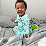 Dallas is registered to the contest to win money with this photo: baby, bed, blanket, child, comfort, cozy, curly_hair, cute, face, gray, green, happy, indoor, infant, pajamas, person, sippy_cup, sleepwear, smiling, tooth