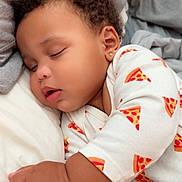Dallas is registered to the contest to win money with this photo: baby, blanket, child, close_up, cozy, curly_hair, cute, earring, hand, indoors, infant, pajamas, peaceful, pillow, pizza_pattern, portrait, resting, skin, sleeping, soft_fabric