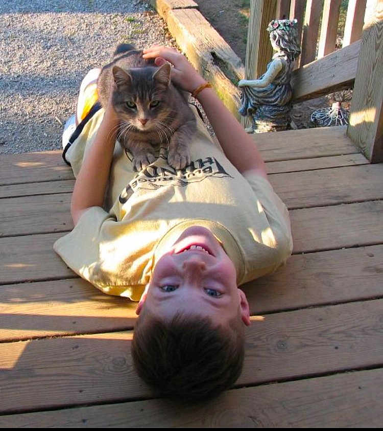 Spartacus joined the competition — help win amazing prizes! boy, cat, wooden_deck, sunlight, outdoor, statue, smiling, pet, relaxing, casual_clothing, daylight, child, animal, playful, nature, portrait, hands, resting, happy, leisure