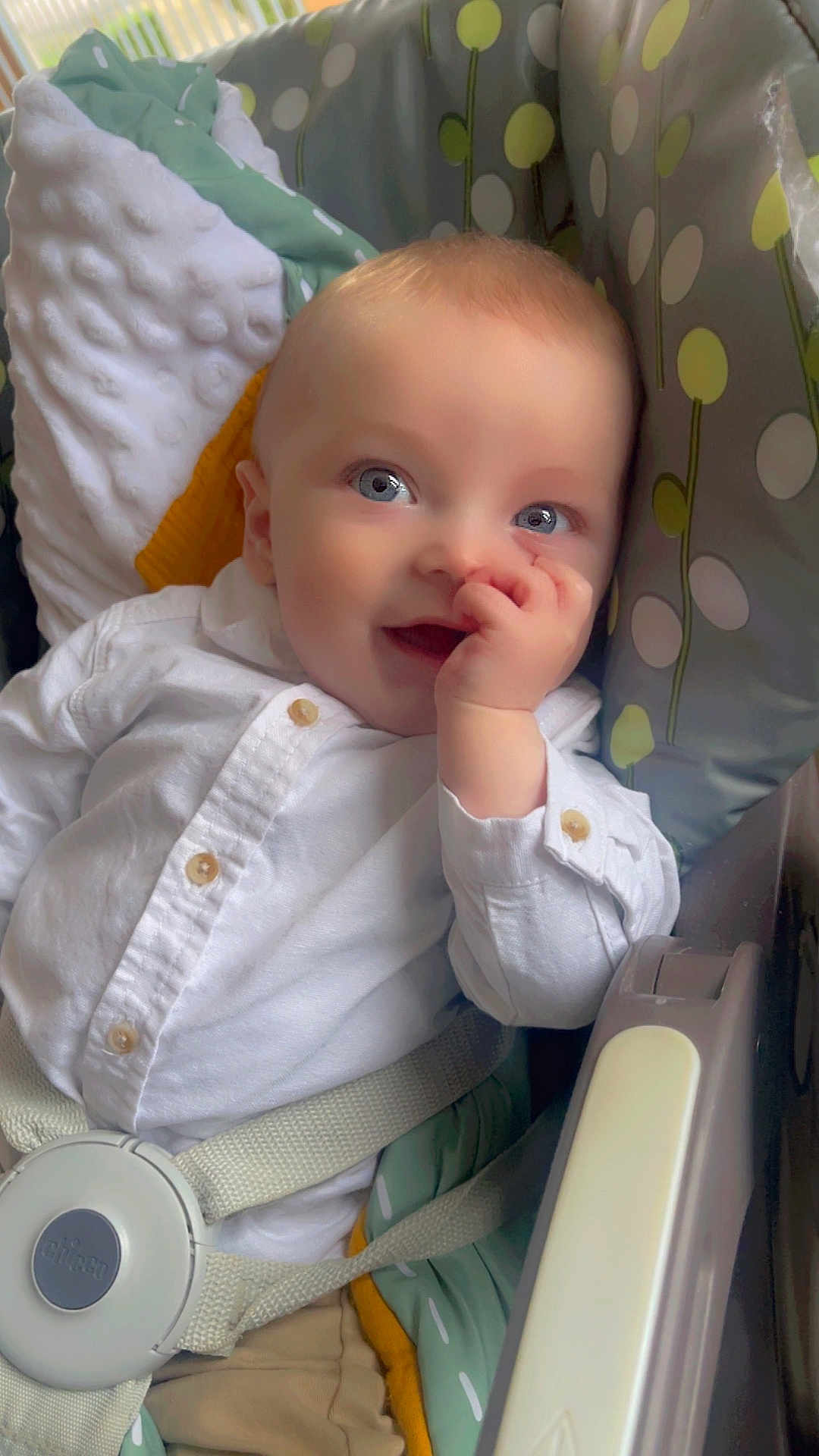 Nino participe au concours pour gagner de l'argent avec cette photo : baby, infant, thumb_sucking, white_shirt, blue_eyes, car_seat, safety_strap, pillow, blanket, polka_dots, patterned_fabric, cute, smile, portrait, indoor, soft_light, hand, face, young_child, happy