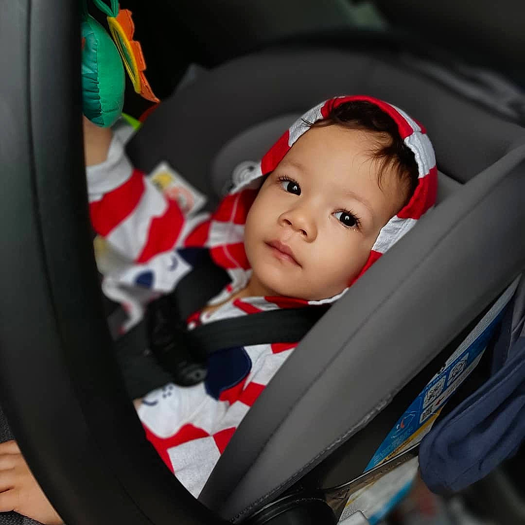 Azriel is registered to the contest to win money with this photo: auto_part, baby, baby_carriage, baby_in_car_seat, baby_products, car_seat, child, head, person, product, seat_belt, smile, steering_wheel, toddler