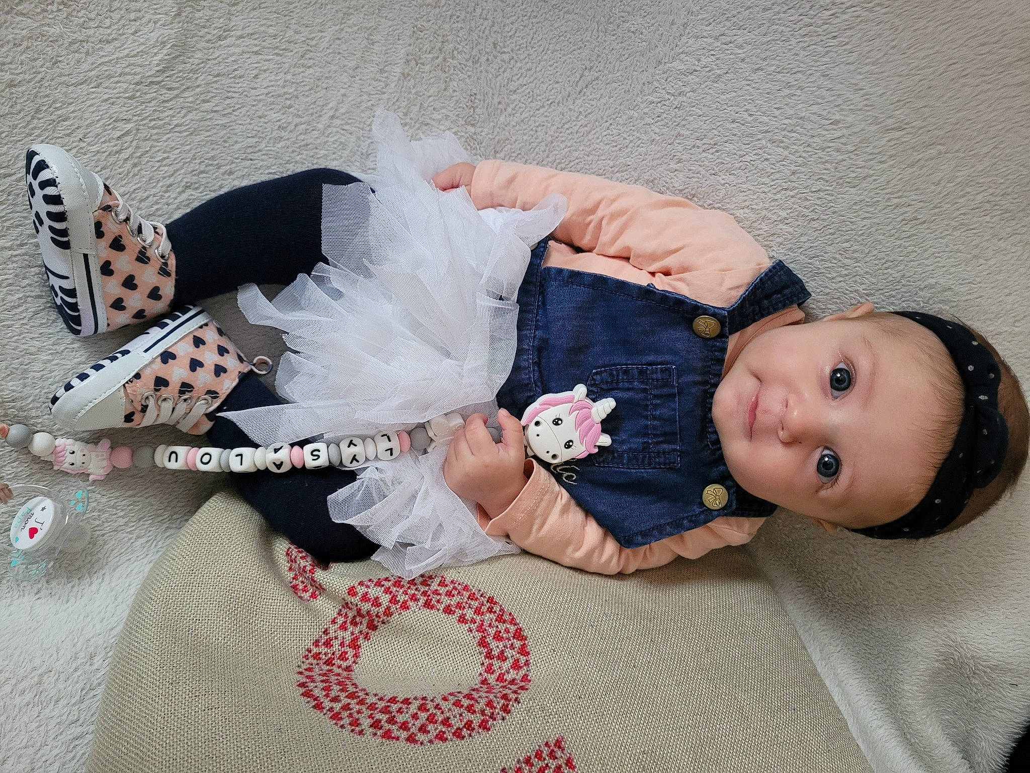 Lysalou participe au concours pour gagner de l'argent avec cette photo : arm, baby, baby_products, baby_toddler_clothing, comfort, doll, dress, eyelash, fashion_accessory, hair_accessory, happy, headgear, linens, pattern, person, pink, sitting, skin, sleeve, textile