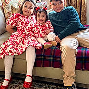 Atarah is registered to the contest to win money with this photo: child, children, sitting, couch, indoor, smiling, family, red_dress, floral_pattern, tights, shoes, window, curtains, carpet, toy, happy, siblings, portrait, home, casual_clothing