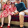 child, children, sitting, couch, indoor, smiling, family, red_dress, floral_pattern, tights, shoes, window, curtains, carpet, toy, happy, siblings, portrait, home, casual_clothing