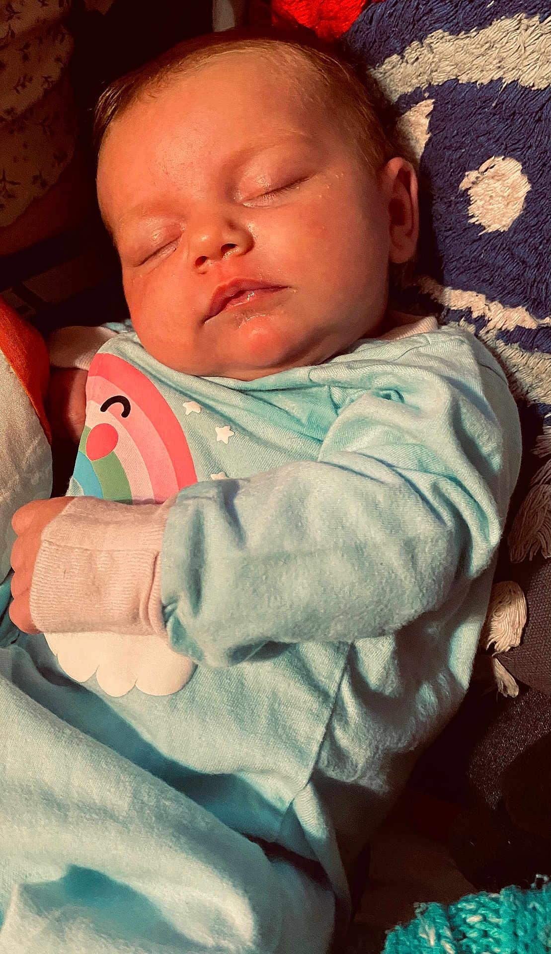 River joined the competition — help win amazing prizes! baby, sleeping, infant, blue_clothing, rainbow, cloud, blanket, cushion, face, hand, cozy, soft_texture, closeup, indoors, peaceful, child, newborn, portrait, nap, warm_lighting