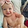 baby, blanket, child, cozy, cute, expression, face, hand, happy, headband, indoors, infant, lying_down, person, pillow, pink_bow, portrait, skin, smiling, soft