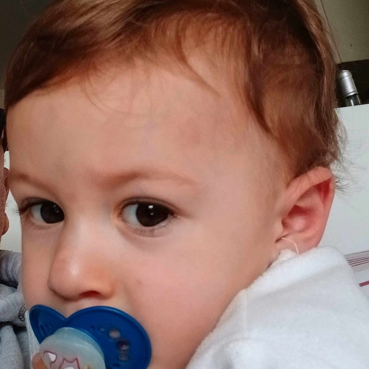 Lorenzo a rejoint le concours — aidez-le/la à gagner de superbes lots ! baby, big_eyes, brown_hair, child, close_up, cozy, curious, cute, ear, expression, face, head, indoor, pacifier, person, portrait, skin, toddler, white_clothing, young