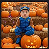 baby, child, pumpkin, jack_o_lantern, halloween, costume, hay_bale, orange, blue_clothing, mittens, hat, outdoor, festive, seasonal, smiling, cute, holiday, portrait, sitting, decoration