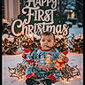baby, child, snow, christmas_lights, plush_toys, holiday, festive_sign, outdoor, winter, sitting, cute, toddler, christmas, santa_hat, playful, lights, cold_weather, smiling, festive_clothing, holiday_decoration