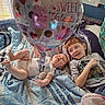 baby, balloon, bed, blanket, blue, casual_clothing, child, cozy, cute, happy, heart, indoor, playful, red_hair, siblings, smile, striped_blanket, toddler, valentine, white