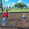 baby, boy, casual_clothing, child, children, clouds, daylight, footwear, fun, grass, greenery, happiness, headband, outdoor, park, playground, sky, smile, swing, trees