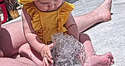 Brooklynn joined the competition — help win amazing prizes! baby, barefoot, child, colorful, curious, fountain, fun, legs, netting, outdoor, person, play_area, sitting, summer, sunflower_pattern, toddler, water, water_play, yellow_hat, yellow_swimsuit