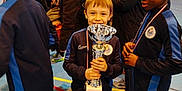 Esteban a rejoint le concours — aidez-le/la à gagner de superbes lots ! child, trophy, medal, sportswear, team, gymnasium, celebration, victory, smile, boy, people, indoor, sports, friends, audience, competition, athlete, happy, event, teamwork