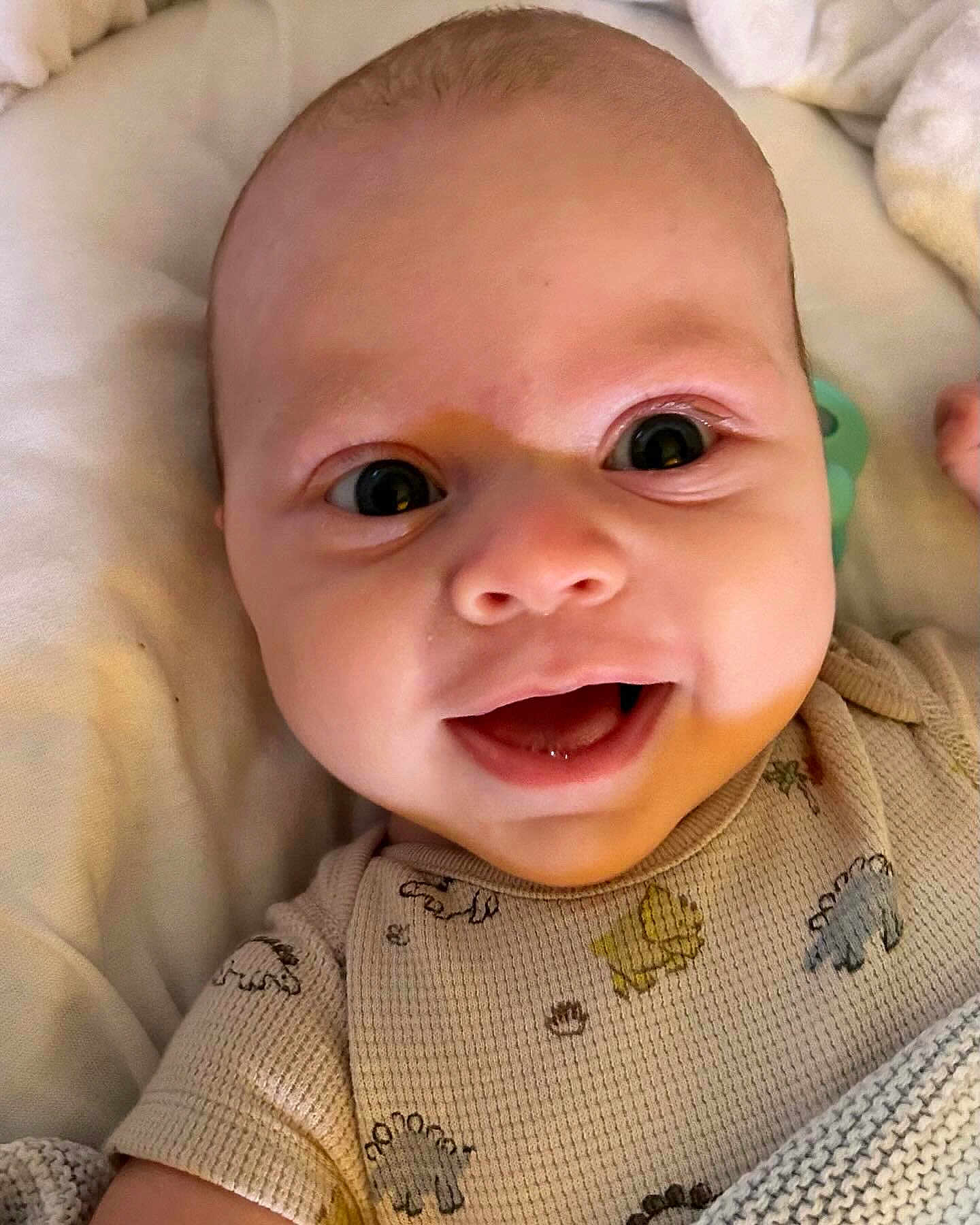 Sorley is registered to the contest to win money with this photo: baby, blanket, child, closeup, clothing, cozy, cute, expression, eyes, face, happy, indoors, infant, lying, newborn, onesie, person, skin, smile, soft