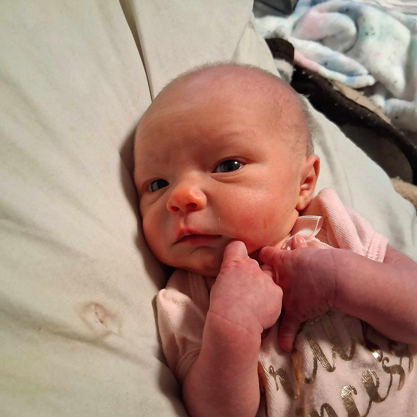 Annabelle Austin is registered to the contest to win money with this photo: baby, bed, blanket, closeup, cute, expression, face, hand, indoors, infant, lying_down, newborn, person, pink_clothing, portrait, resting, skin, sleepwear, small_hands, young_child