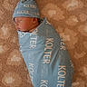 Kolter is registered to the contest to win money with this photo: newborn, baby, swaddle, hat, sleeping, carpet, soft_texture, blue, infant, peaceful, cute, resting, portrait, child, cozy, warm, sleep, wrapped, indoors, person